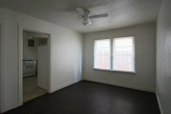 an empty room with a window and a ceiling fan