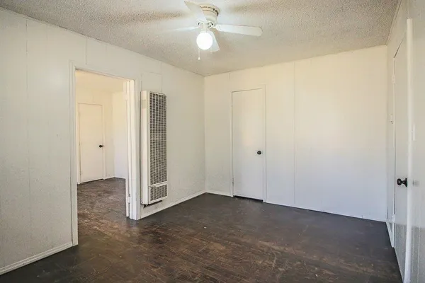 an empty room with closet and a chandelier fan