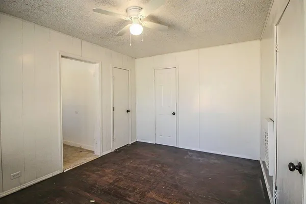 an empty room with a ceiling fan and a window