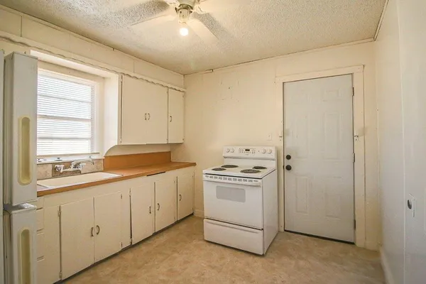 a kitchen with white cabinets and white appliances