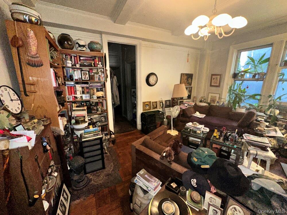 203 West 81st Street, Unit 4E Manhattan, NY 10024 - Photo 11 of 17 a living room with lots of white furniture and chandelier
