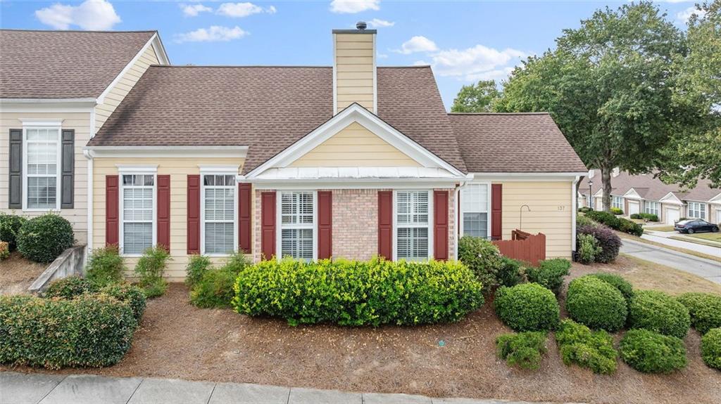 a view of a house with potted plants and a yard