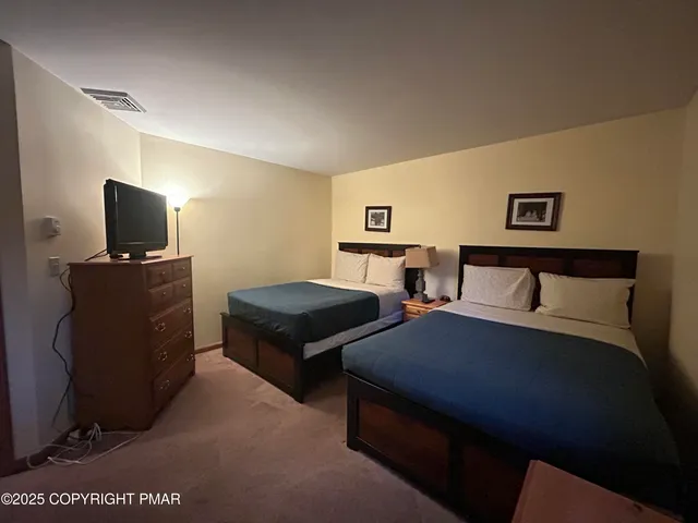 a bedroom with two beds and a television