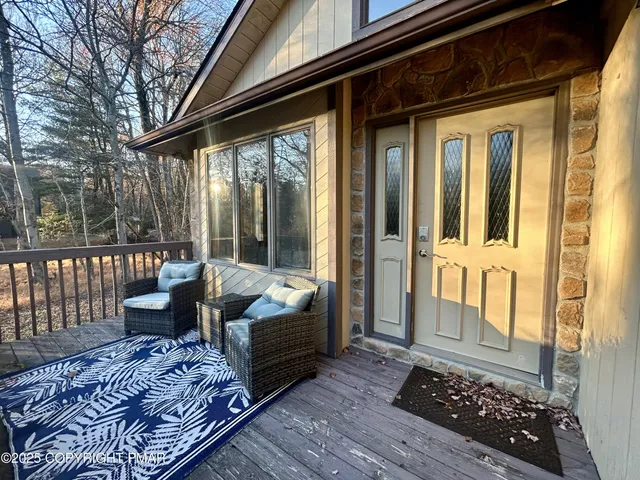 a view of a porch with furniture and wooden floor