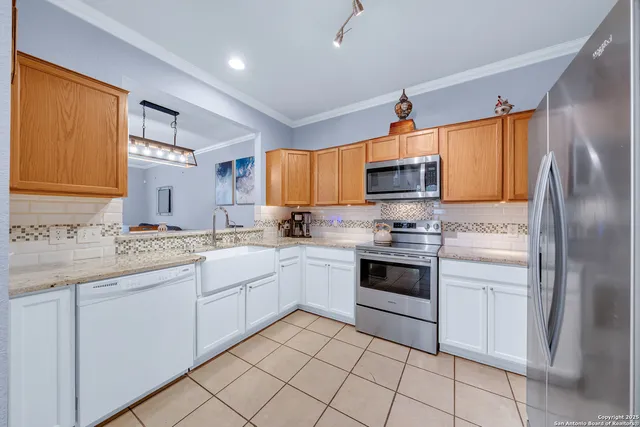a kitchen with granite countertop a sink stainless steel appliances and cabinets