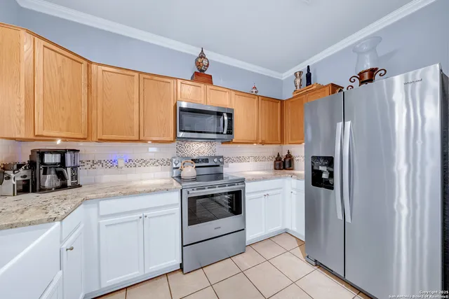 a kitchen with granite countertop a refrigerator stove and sink