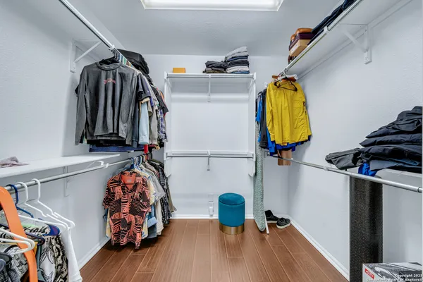 a view of walk in closet with clothes and shoes
