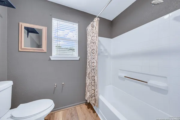 a white toilet sitting next to a bath tub