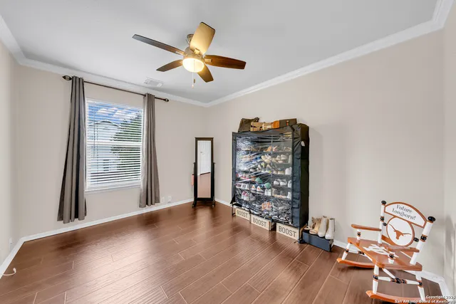 a view of an empty room with a window and wooden floor