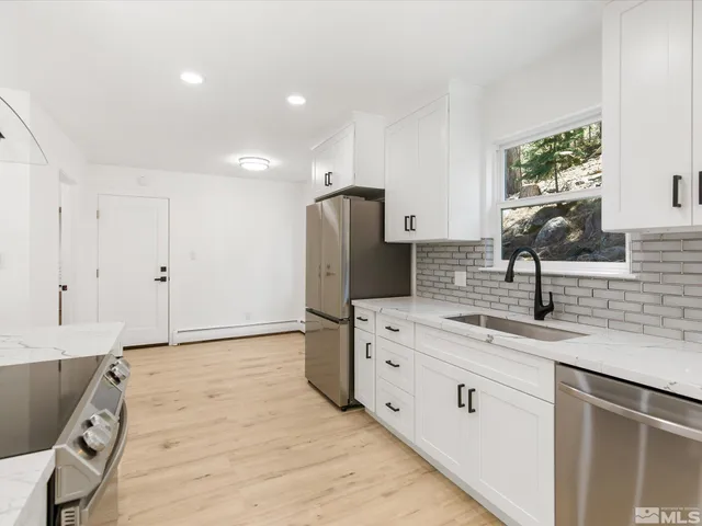 a kitchen with stainless steel appliances granite countertop a sink stove and cabinets