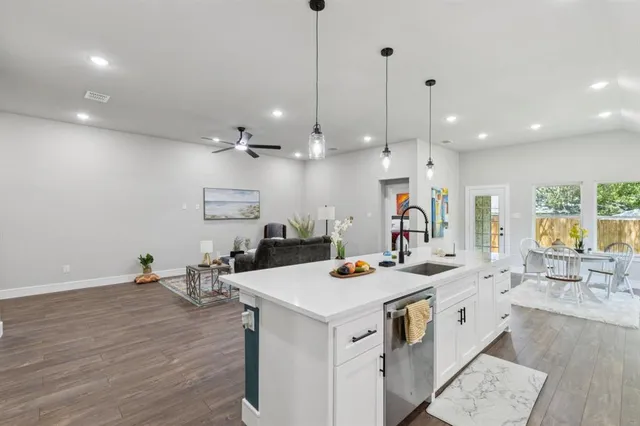 a kitchen that has a lot of cabinets and wooden floor