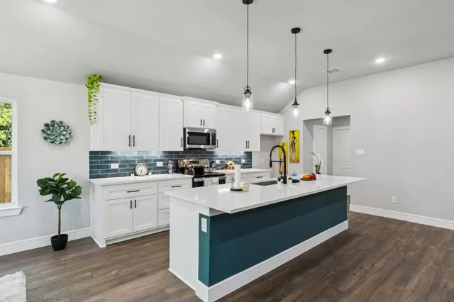 a kitchen with counter top appliances and cabinets