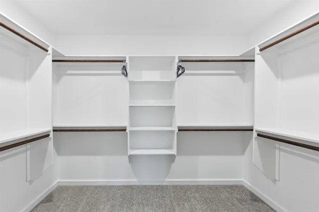 a view of walk in closet with empty racks