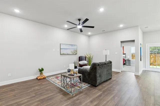 a living room with furniture and a wooden floor