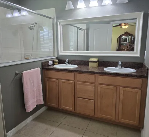 a living room with furniture a flat screen tv and a refrigerator