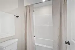a bedroom with a bed a window and dresser