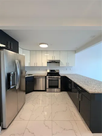 a kitchen with stainless steel appliances granite countertop a stove a sink and a refrigerator
