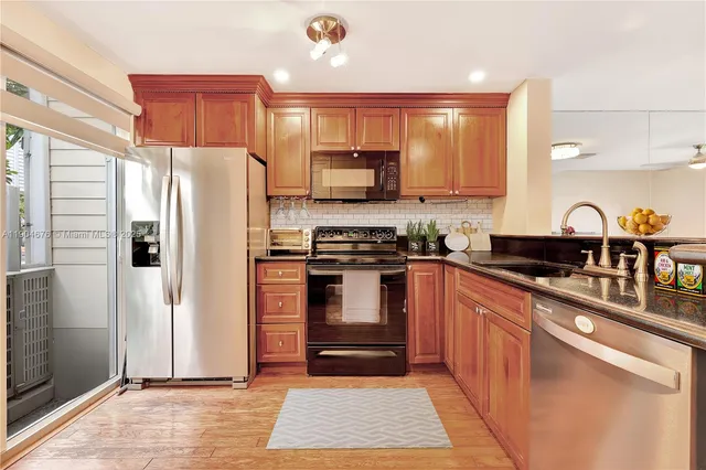 a kitchen with stainless steel appliances granite countertop a refrigerator stove and oven