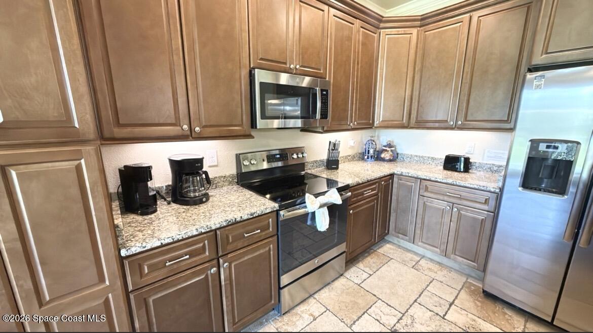2709 Cutlass Point Lane, Unit 103 Merritt Island, FL 32953 - Photo 9 of 31 a kitchen with stainless steel appliances granite countertop a sink stove and microwave