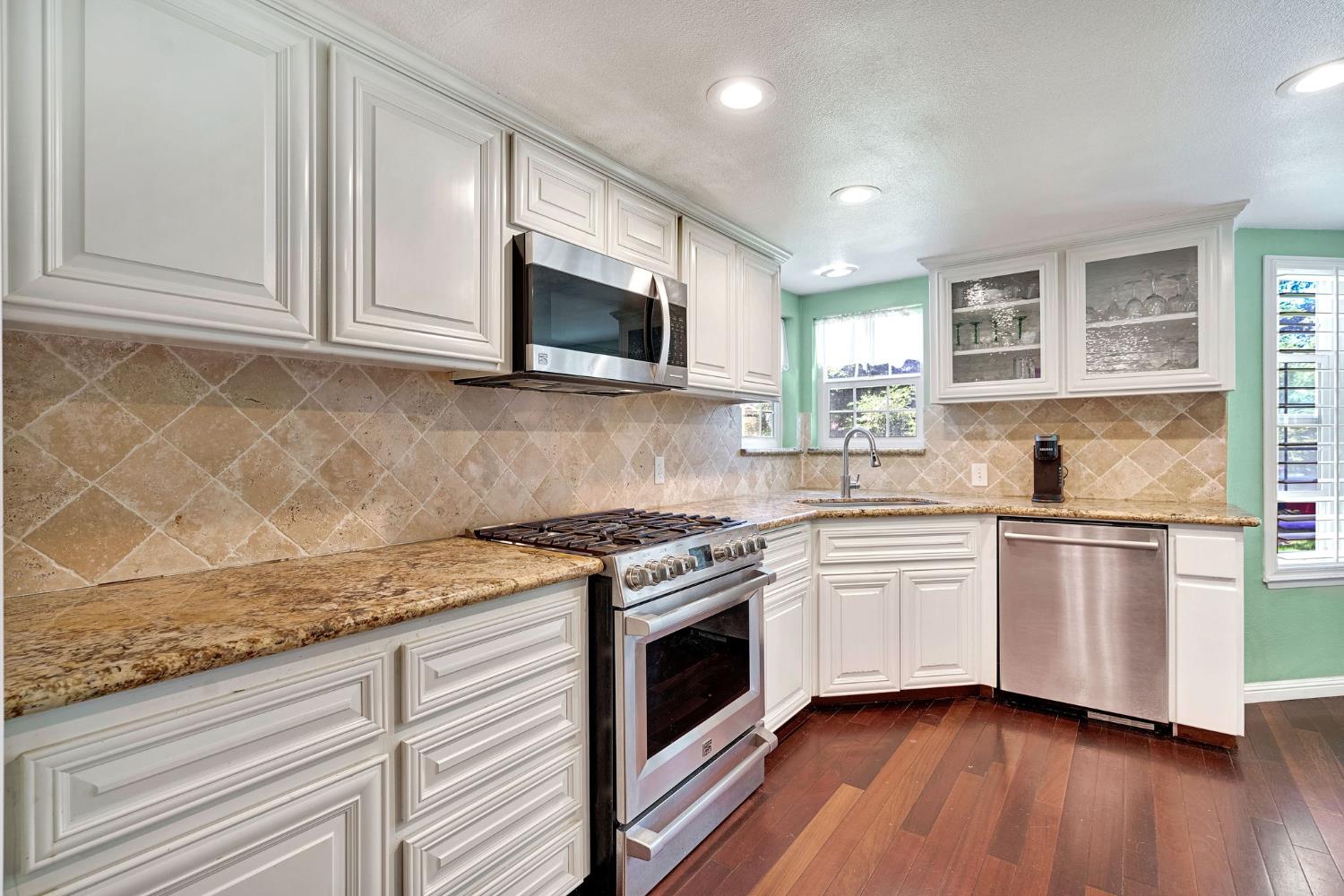 200 Lyons Street Madera, CA 93638 - Photo 14 of 32 a kitchen with stainless steel appliances granite countertop a sink and a stove