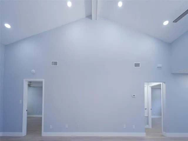 a view of an empty room with wooden floor and closet