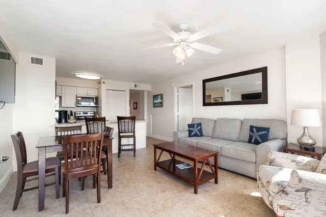 a living room with furniture a flat screen tv and a large window