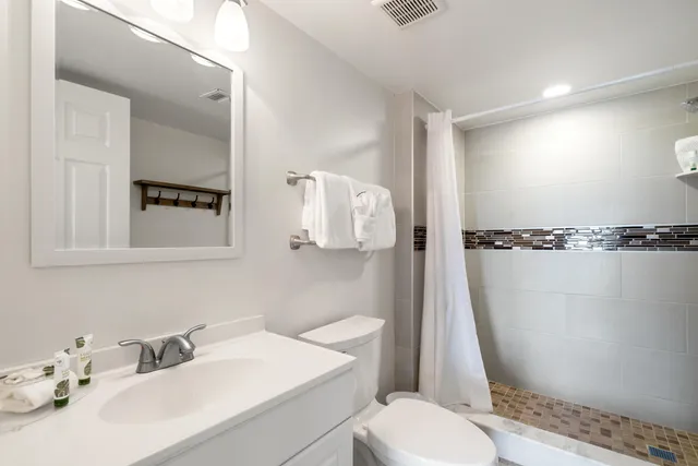 a bedroom with a large bed and a flat tv screen on dresser