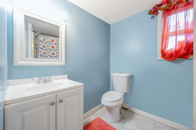 a bathroom with a toilet a sink and a window