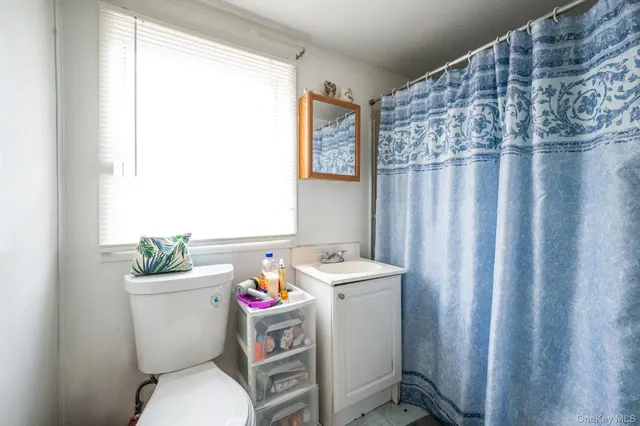 a white toilet sitting next to a bathroom sink and a window