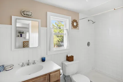 a bathroom with a sink toilet a mirror and shower