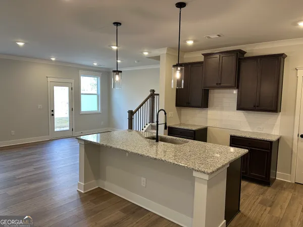 a kitchen with kitchen island granite countertop a sink a counter top space stainless steel appliances and cabinets
