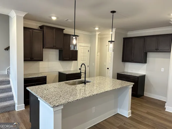 a kitchen with a sink a counter top space stainless steel appliances and a ceiling fan