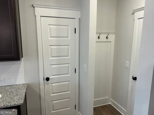 a view of a hallway with the kitchen and wooden floor