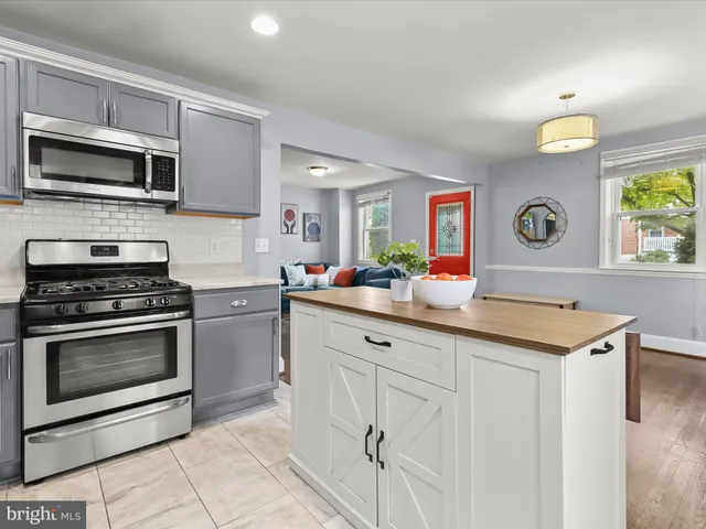 a kitchen with stainless steel appliances a refrigerator sink and white cabinets