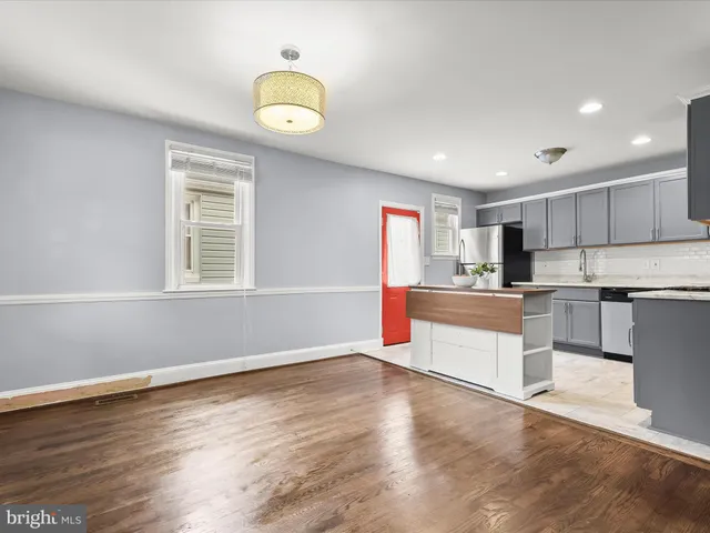 a kitchen with a refrigerator and a stove top oven