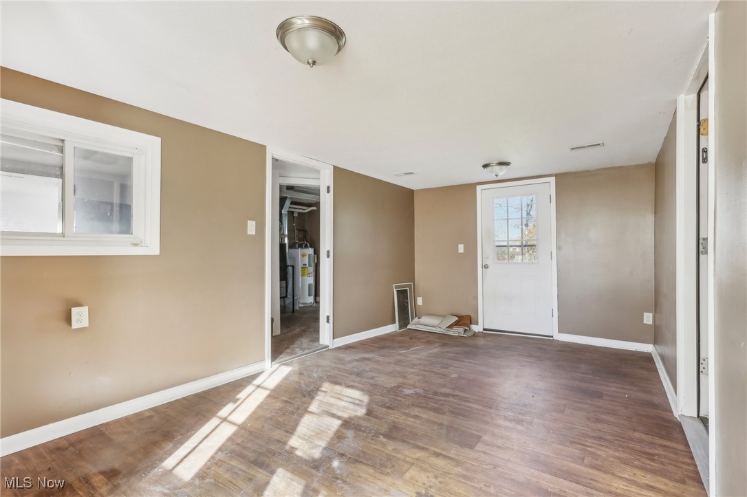 1733 Ronald Road Akron, OH 44312 - Photo 16 of 33 Spare room featuring dark wood-type flooring and electric water heater