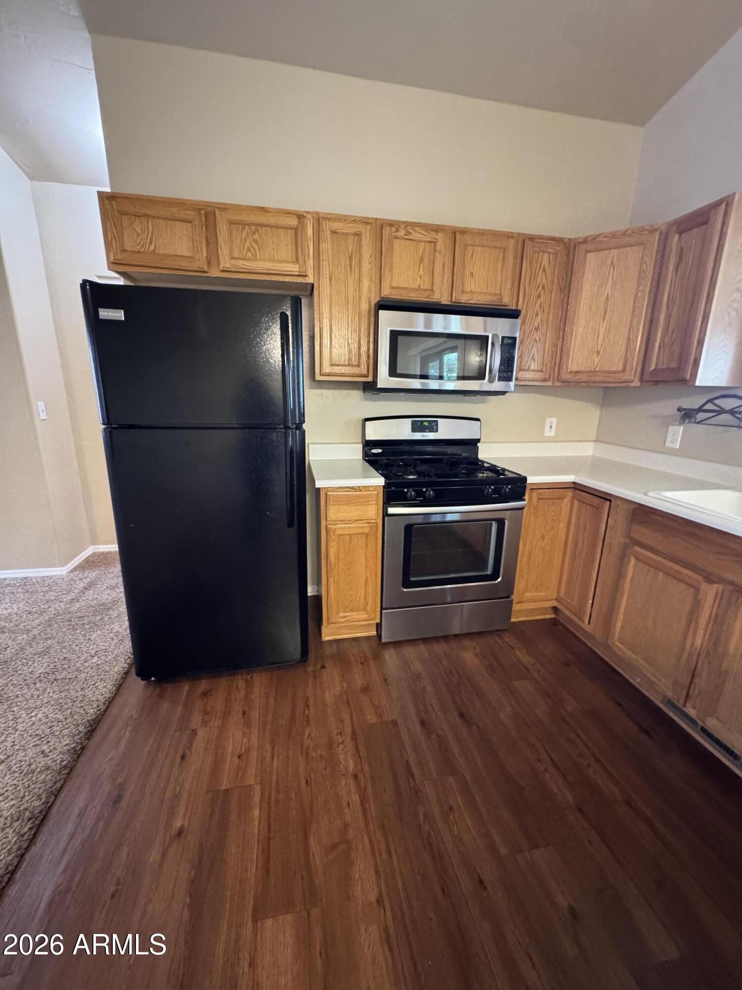 574 Walnut Creek Loop Pinetop, AZ 85935 - Photo 8 of 23 a kitchen with wooden floors and stainless steel appliances
