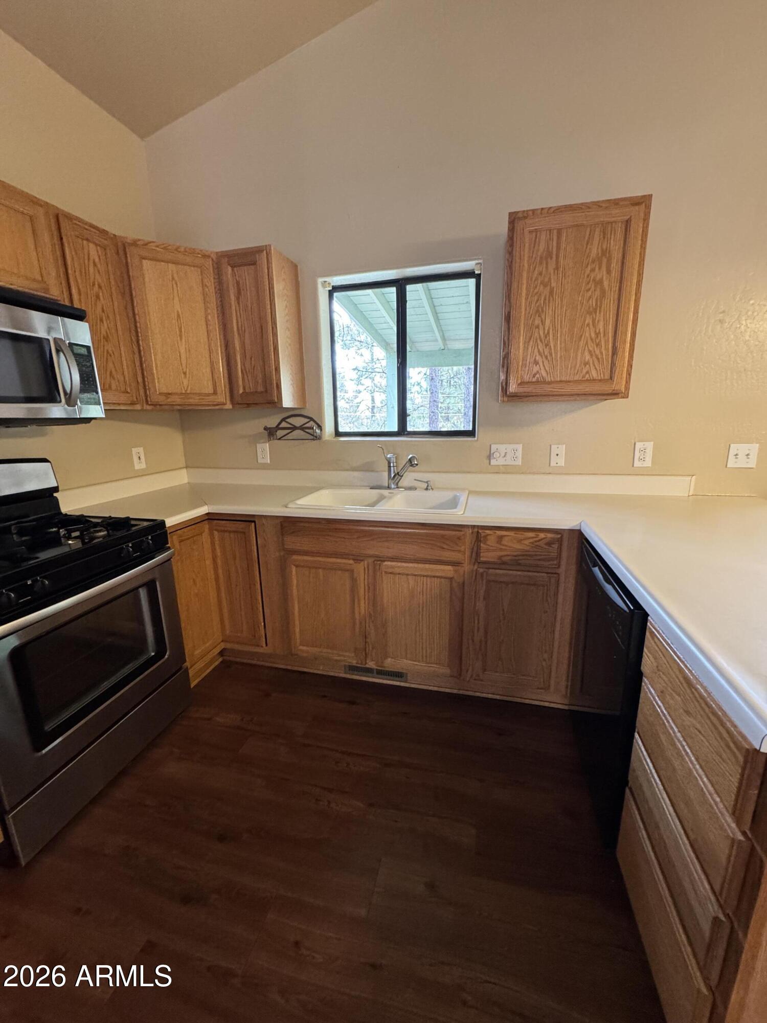 574 Walnut Creek Loop Pinetop, AZ 85935 - Photo 9 of 23 a kitchen with stainless steel appliances wooden cabinets a stove a sink and a microwave