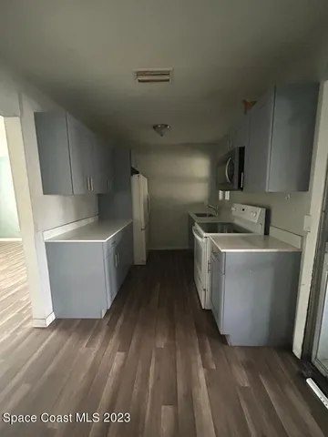 a room with wooden floor washer and dryer