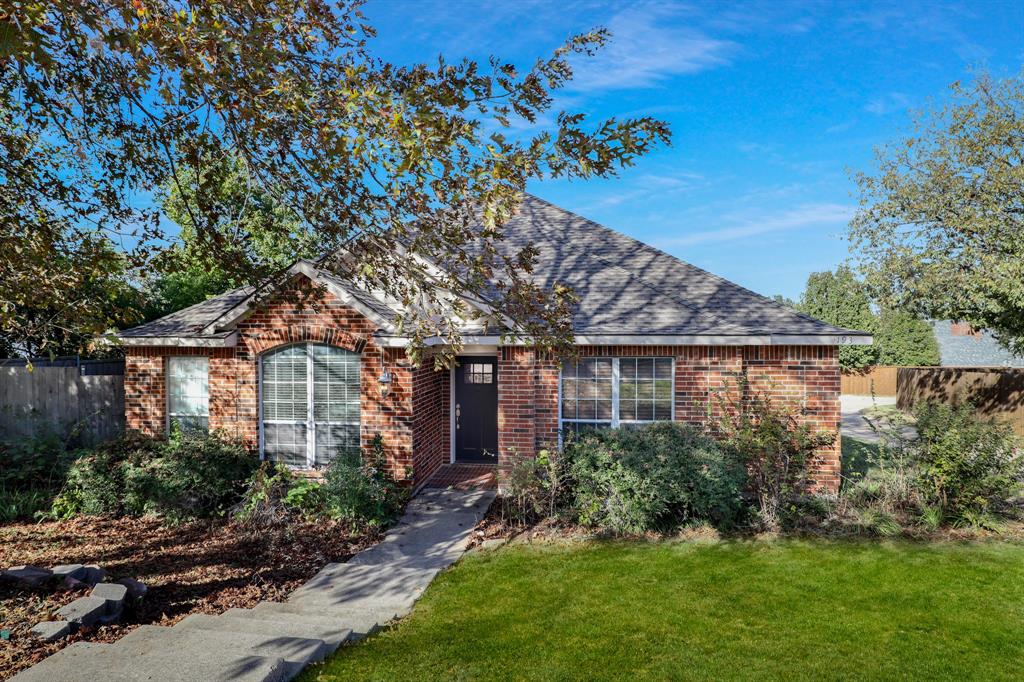 Single story home featuring brick siding and a shingled roof