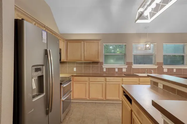 a kitchen with a sink a refrigerator and cabinets