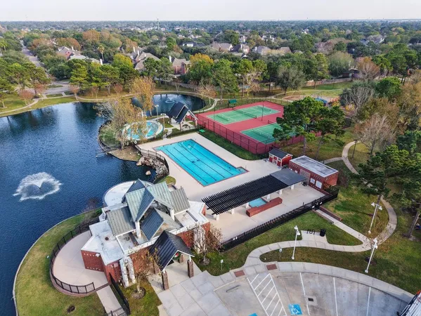 an aerial view of a house with a garden and lake view