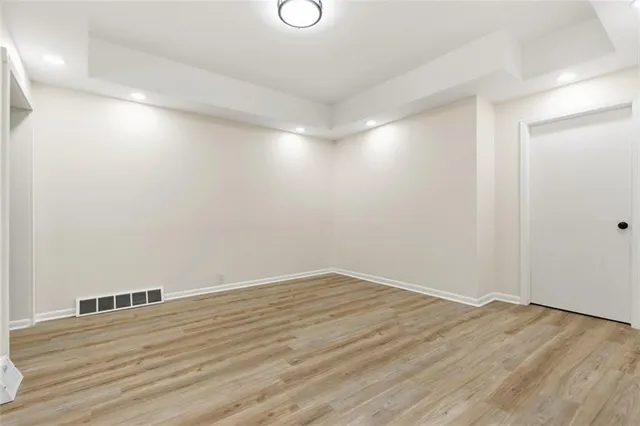 a view of an empty room with wooden floor