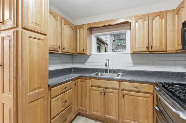 a kitchen with stainless steel appliances granite countertop a sink and a white cabinets