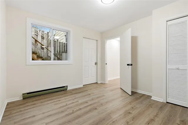 an empty room with wooden floor and window