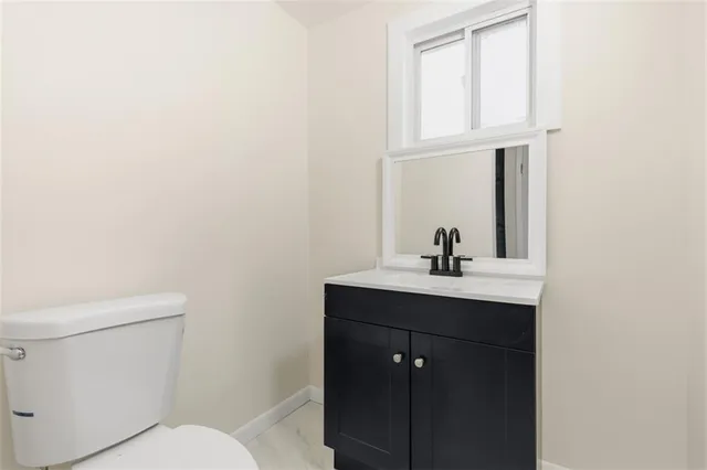 a bathroom with a toilet a sink a vanity and mirror