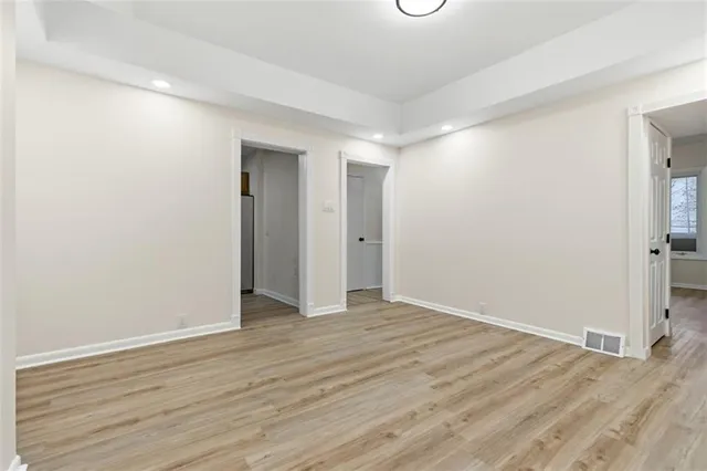 a view of an empty room with wooden floor