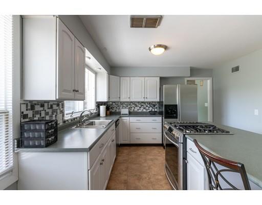 87 Hillview Road Holyoke, MA 01040 - Photo 8 of 26 a kitchen with stainless steel appliances a sink a stove a refrigerator cabinets and a window