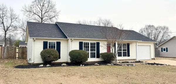 a view of a house with backyard and trees