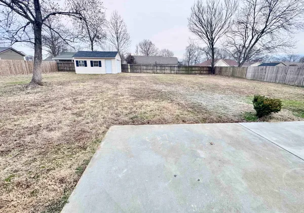 a view of house with yard and trees